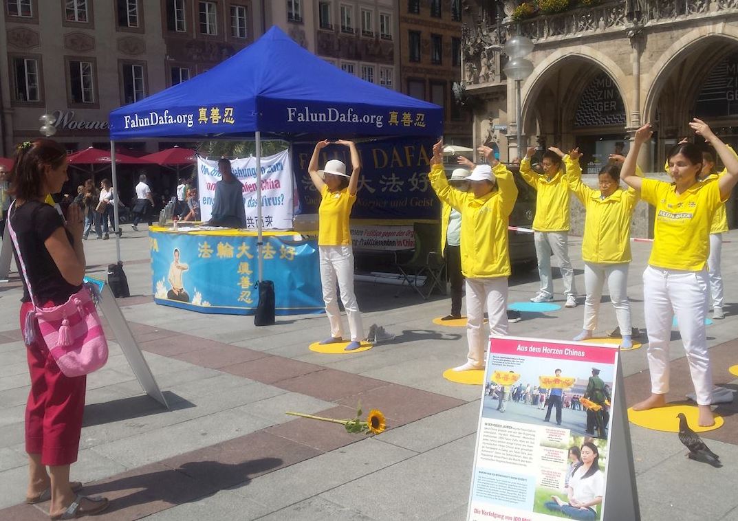 Image for article Alemanha: moradora de Munique oferece uma flor aos praticantes do Falun Gong durante atividades para aumentar a conscientização sobre a perseguição