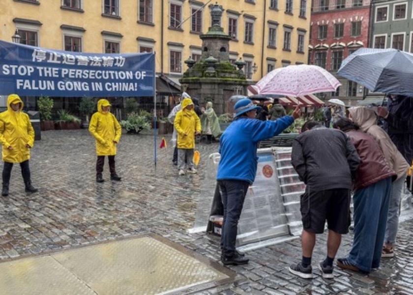 Image for article ​O público assina uma petição pelo fim da perseguição durante um evento em frente ao Museu do Prêmio Nobel em Estocolmo